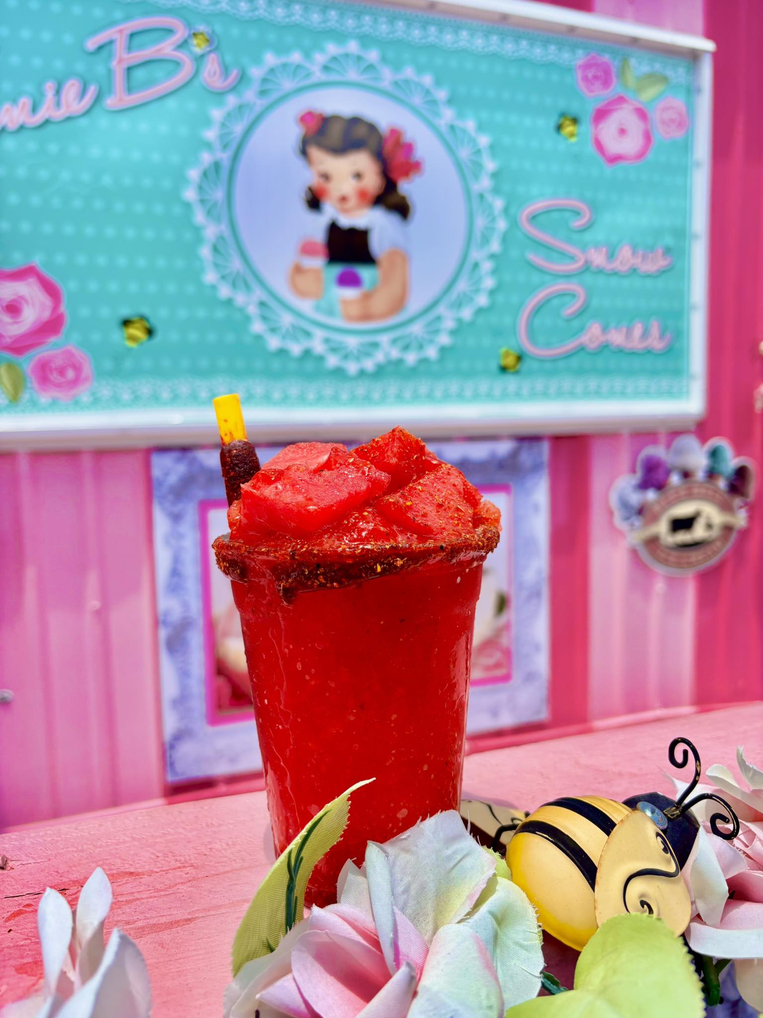 Red mangonada snowcone with chamoy and candy straw at Junie B’s Snowcones stand